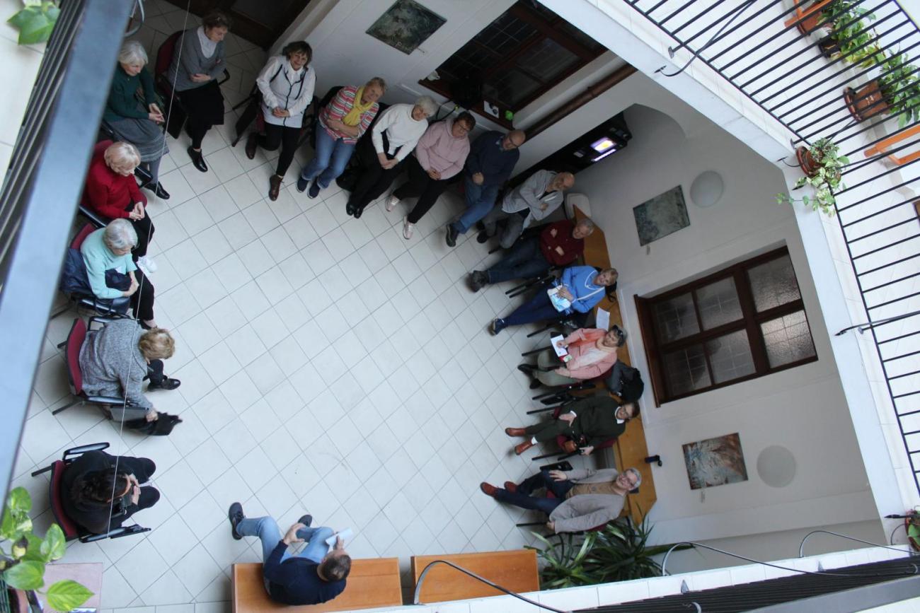 Účastníci Univerzity tretieho veku pri spoločnom dialógu v átriu fakulty